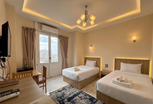 a hotel room with two beds and a television at Via Cairo hotel in Cairo