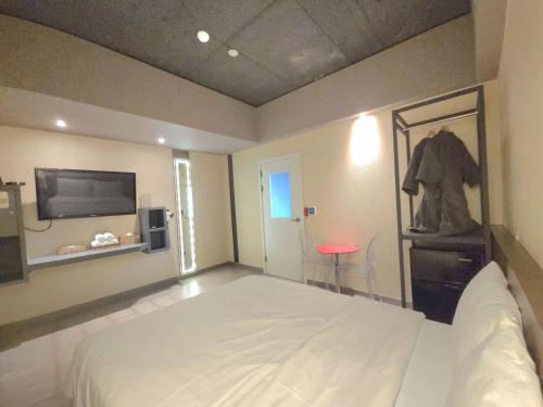 a bedroom with a large white bed and a flat screen tv at AREA HoTEL in Yeongju