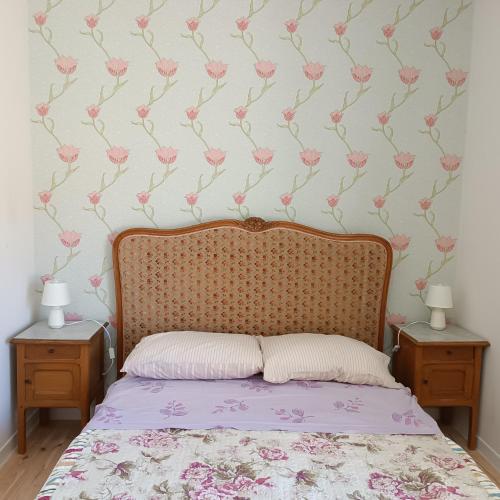 a bedroom with a bed with pink flowers on the wall at Pyrenees Vue Gite - Owl - Vues Fantastique, Petit-Déjeuner, Calme, Piscine, Parking - Brand New in Saint-Gaudens