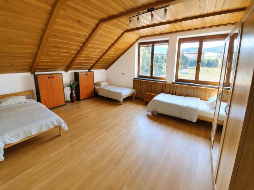a large room with two beds and two windows at Vila Bělá pod Pradědem in Bělá pod Pradědem