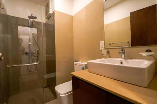 a bathroom with a sink and a shower and a toilet at Ceylon Vacation - Negombo in Negombo