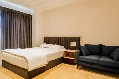 a bedroom with a bed and a couch at Ceylon Vacation - Negombo in Negombo