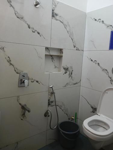 a bathroom with marble walls and a toilet at Seabay Bliss Varkala by Ojes in Varkala