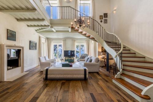 a living room with a staircase with a couch and chairs at Villa Avola Bol Exclusive Beach Access in Bol