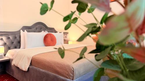 a bedroom with a bed with a red pillow and a plant at Stavilar Hotel - Charming Stay Just Steps Away from Peles Castle in Sinaia in Sinaia