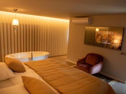 a bedroom with a large bed and a bath tub at Quinta Tapada do Vale in Vila Meã