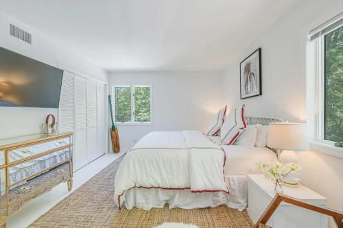 a white bedroom with a large bed and windows at Villa Sapphire Bay in Sag Harbor