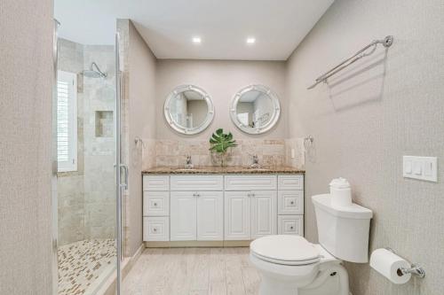 a bathroom with a toilet and a shower and mirrors at Villa Sapphire Bay in Sag Harbor