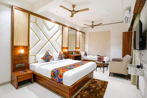 a hotel room with a large bed and a chair at FabHotel Status Residency in Mumbai