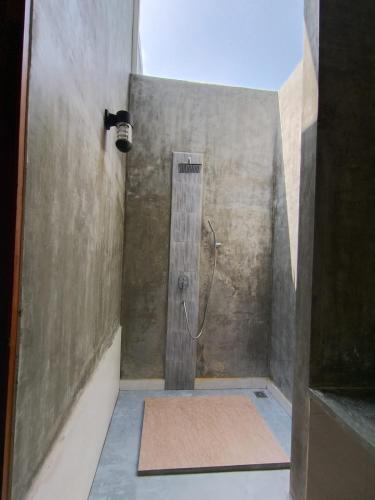 a shower with a shower head in a bathroom at Madi Beach Guesthouse in Maalhos