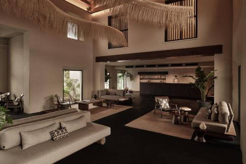 a living room with couches and tables and chairs at OKU Andalusia in La Alcaidesa