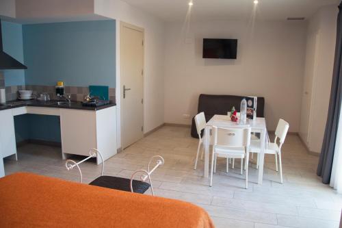 a kitchen and a dining room with a table and chairs at Apartamentos Comfort Calella in Calella