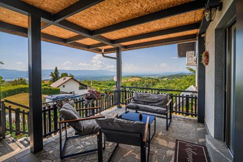 a patio with chairs and a table on a balcony at Vista Apartment With Hot Tub & Large Terrace in Leskovec pri Krškem