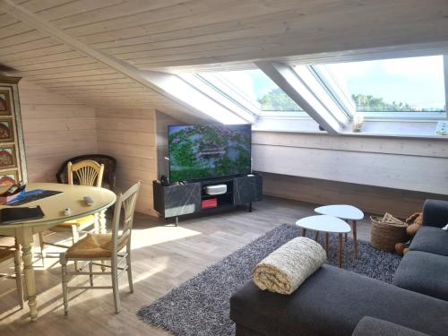 a living room with a couch and a tv and a table at Finn Lodge in Saint-Denis-dʼOléron