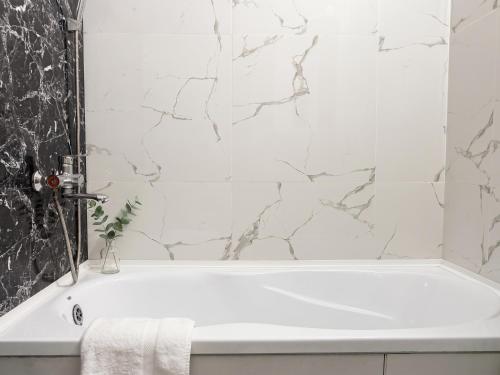 a white bath tub in a bathroom with marble walls at new stail centr in Bălţi