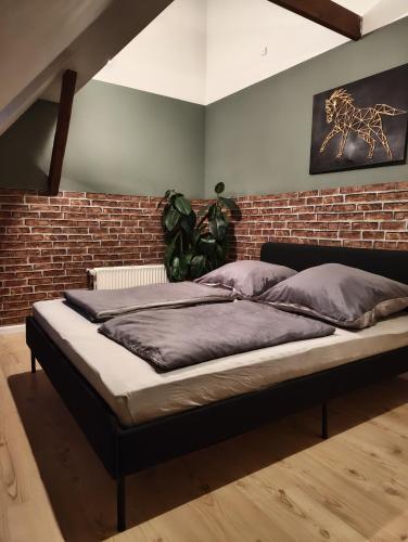 a bed in a room with a brick wall at HyggeHome Strandelhjørn in Vojens