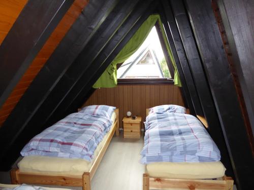 two beds in a room with a window at Eifelwaldhäuschen in Blankenheim
