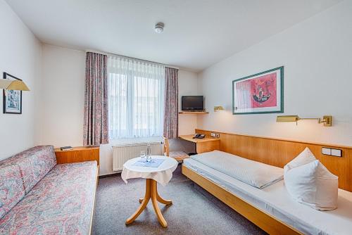ein Hotelzimmer mit Sofa und Tisch in der Unterkunft Hotel Hasenmayer in Pforzheim