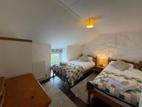 a bedroom with two twin beds and a table at Derlwyn in Newport