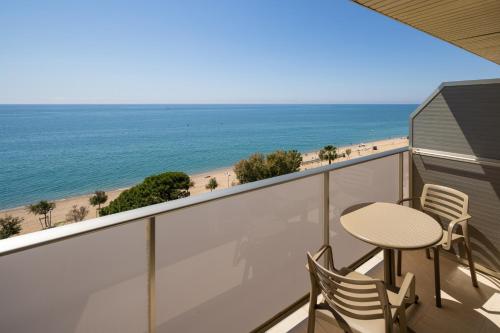 a balcony with a table and chairs and the beach at htop Pineda Palace SPA 4Sup - Bliss - Adults Only Plus 18 in Pineda de Mar