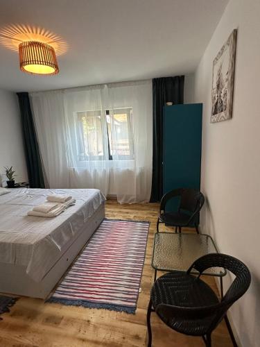a bedroom with a bed and two chairs in it at Acasa la Coana Mare in Bălăneşti