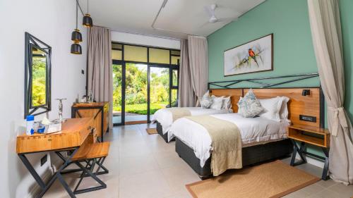 a hotel room with two beds and a desk and a desk at Waterfalls Lodge in Victoria Falls