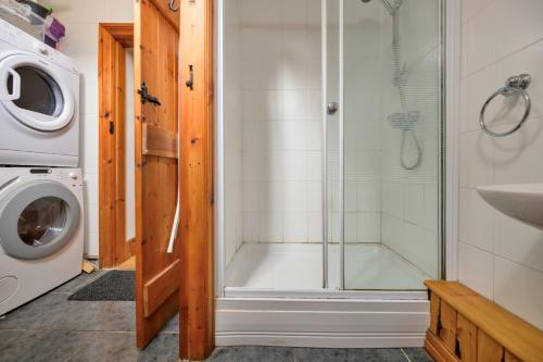 a bathroom with a shower and a washing machine at Finest Retreats - Gladstone in Aberdaron