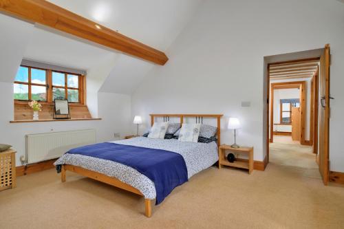 a bedroom with a bed with blue sheets and a window at Finest Retreats - Gladstone in Aberdaron
