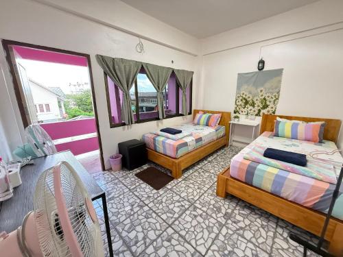 a bedroom with two beds and a table with chairs at Madam Guesthouse in Krabi