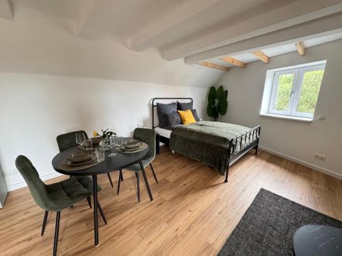 a living room with a bed and a table and chairs at Steigerwald Habitat in Oberschwarzach