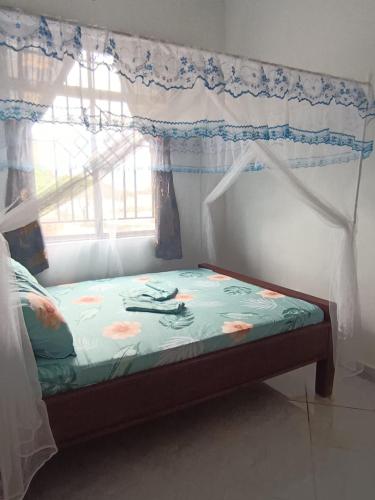 a bed in a room with a window at Ubuntu Home in Mto wa Mbu