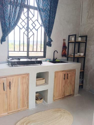 a kitchen with a sink and a window at Ubuntu Home in Mto wa Mbu