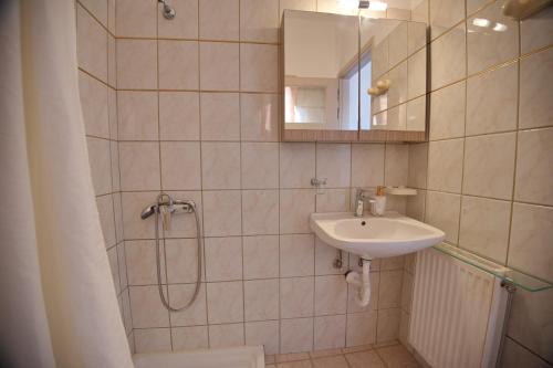 a bathroom with a shower and a sink and a mirror at Ikos Studios and Apartments in Patitiri