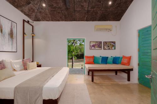 a room with two beds and a bench in it at Yala Villa in Yala