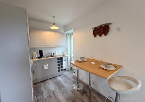 a small kitchen with a table and a counter at Studio central équipé in Compiègne