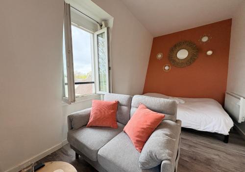 a living room with a couch and a bed at Studio central équipé in Compiègne