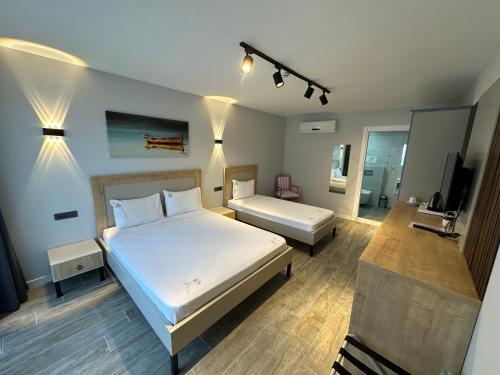 a bedroom with a large white bed and a television at Duman Boutique Hotel Cesme in Çeşme