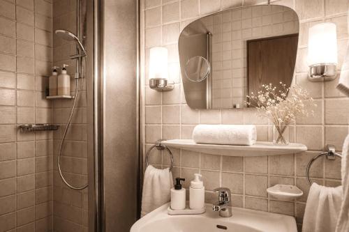 a bathroom with a sink and a mirror at REDBERRY Hotel - Düsseldorf - Neuss in Neuss