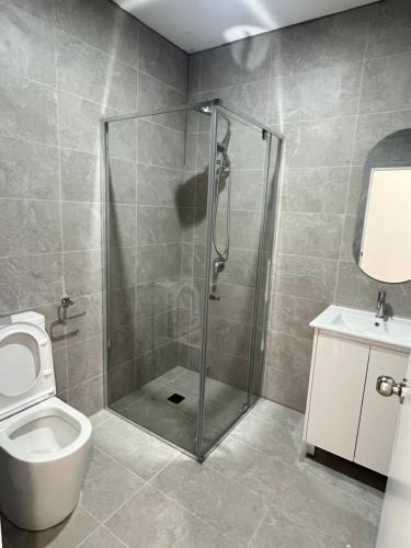 a bathroom with a shower with a toilet and a sink at Spacious Queen Room - Train Station - NG5 in Guildford