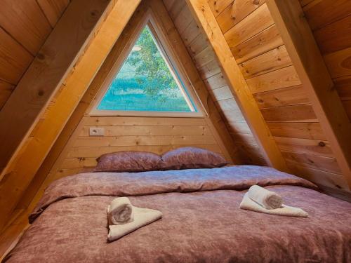 a bed in a room with a large window at Ognjiste Komarnice in Komarnica