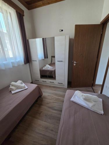 a bedroom with two beds and a large mirror at Alyki Stone House 3 in Alyki