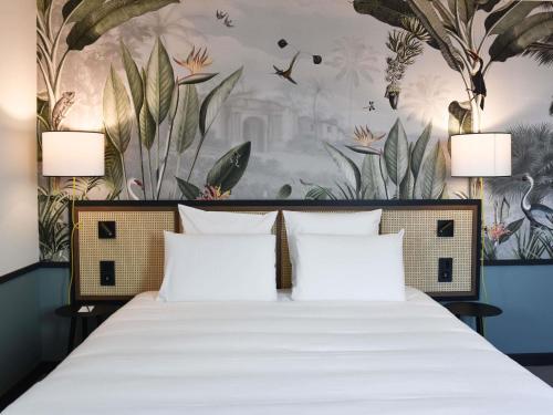 a bedroom with a large bed with a floral wallpaper at Mercure Le Mans Batignolles - Hotel & Spa in Le Mans