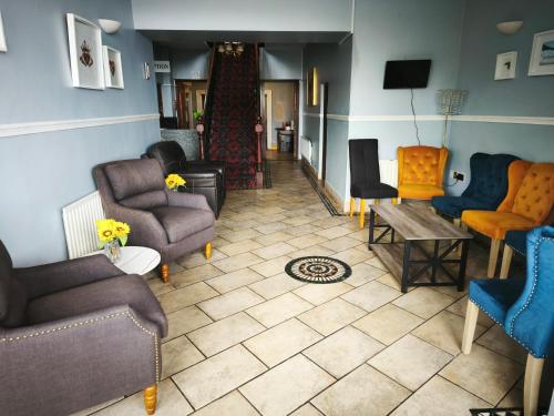 a living room with couches and chairs and a floor at The Strand, Dugort Achill in Achill
