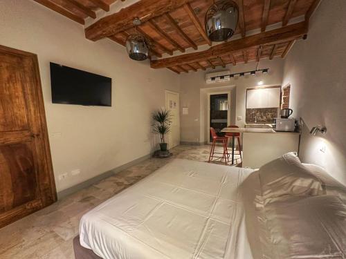 a bedroom with a large bed and a kitchen at La Casina Room in Castelmuzio