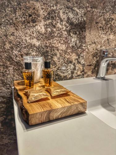 two bottles on a wooden cutting board next to a sink at La Casina Room in Castelmuzio