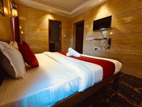 a bedroom with a large bed with a tv on the wall at PV Tower - Auro Beach in Kuilapayam