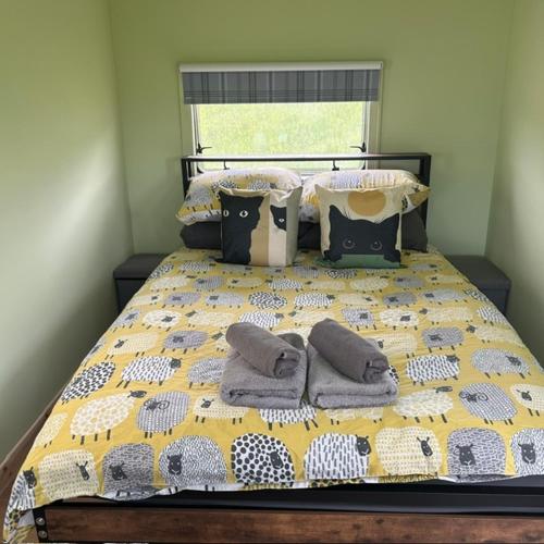a bed with towels and pillows on it at the buttercup shed in Lochcarron