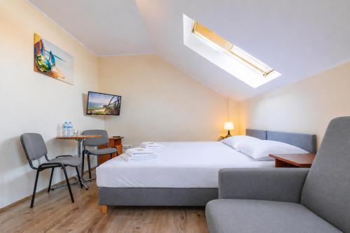 a hotel room with a bed and a table and chairs at Willa Chantal in Jastrzębia Góra