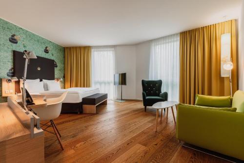a hotel room with a bed and a desk at Grimm´s Berlin Potsdam in Teltow