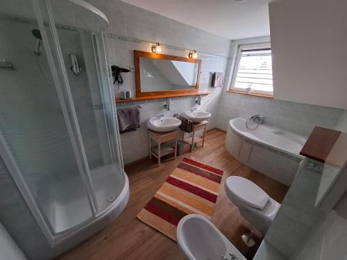 a bathroom with two sinks and a shower at Susann Vendégház in Szigetmonostor
